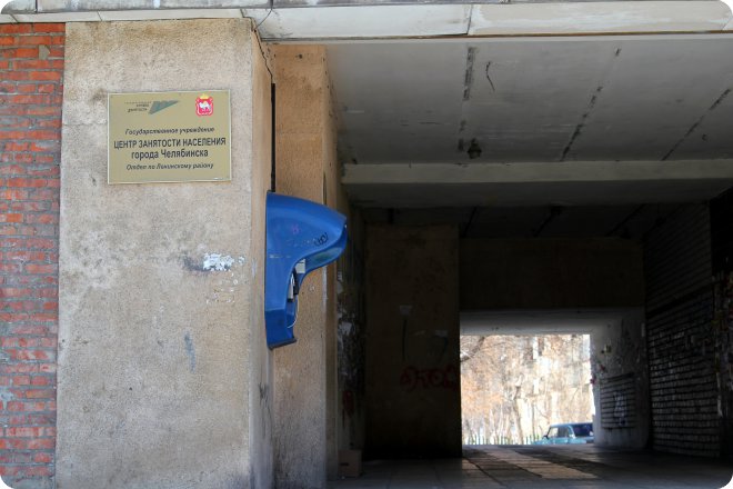 Табличка на стене: «Государственное учреждение ЦЕНТР ЗАНЯТОСТИ НАСЕЛЕНИЯ города Челябинска. Отдел по Ленинскому району». Синий объект на стене, вход в туннель.