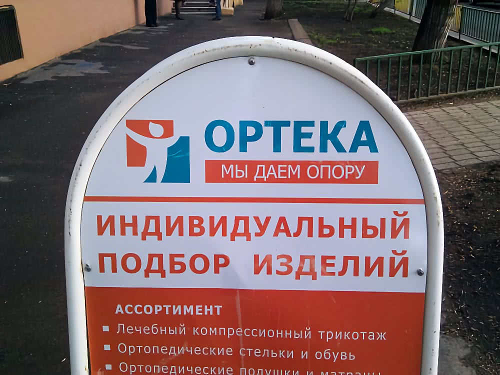 Вывеска «ОРТЕКА. Мы даем опору» с надписью «Индивидуальный подбор изделий» и перечнем: лечебный компрессионный трикотаж, ортопедические стельки и обувь, подушки и матрасы.