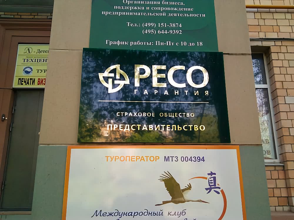 Витрина с вывесками: «РЕСО ГАРАНТИЯ» (страховое общество, представительство), «ТУРОПЕРАТОР МТЗ 004394» и контактная информация.