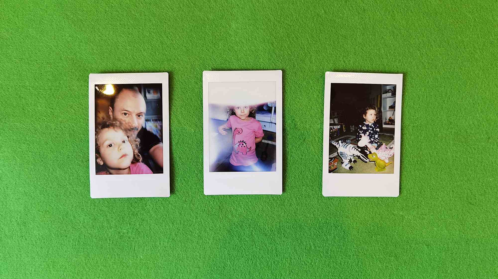 Три полароидных снимка на зелёном фоне: слева — мужчина и ребёнок, в центре — девочка в розовой футболке с динозавром, справа — ребёнок с игрушечными динозаврами.